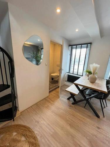 a living room with a table and a mirror at Gezellig appartement, Gerenoveerd eind 2022 in Tilburg