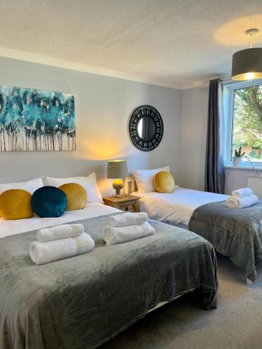 ein Schlafzimmer mit 2 Betten mit Kissen darauf in der Unterkunft Bright and spacious two bed apartment with roof terrace in Hoddesdon in Hoddesdon