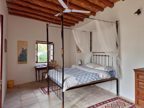ein Schlafzimmer mit einem Himmelbett mit Decke in der Unterkunft Cyprus Village House in Kyrenia