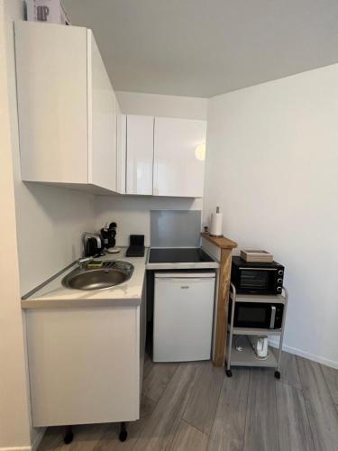 une petite cuisine avec des armoires blanches et un évier dans l'établissement 103 T2 Hyper centre Meaux, à Meaux