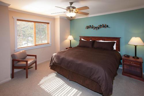 1 dormitorio con 1 cama, 1 silla y ventilador de techo en Beaver Brook on the River, en Estes Park