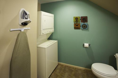 a bathroom with a toilet and a washer and dryer at Beaver Brook on the River in Estes Park