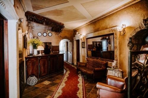 a living room with a couch and a table and chairs at Hotel Senator in Zamość