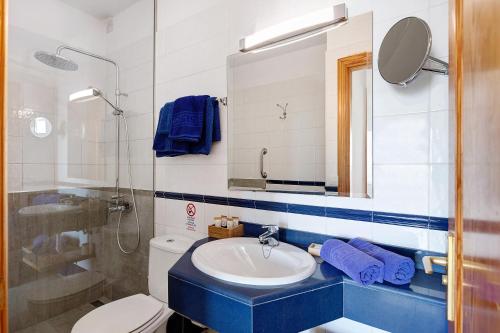 een badkamer met een wastafel, een toilet en een spiegel bij Callao Beach 2 in Arrieta