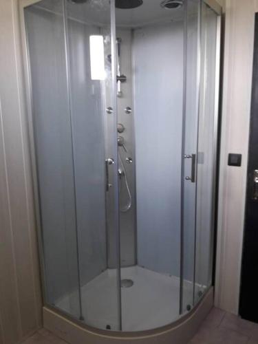 eine Dusche mit Glastür im Bad in der Unterkunft Gite Au Marianne in Jû-Belloc