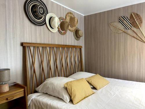 - une chambre avec un lit avec des chapeaux sur le mur dans l'établissement Ma cabane sous les arbres, à Soulac-sur-Mer