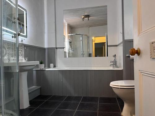 een badkamer met een bad, een wastafel en een toilet bij Tregwylan in Nefyn