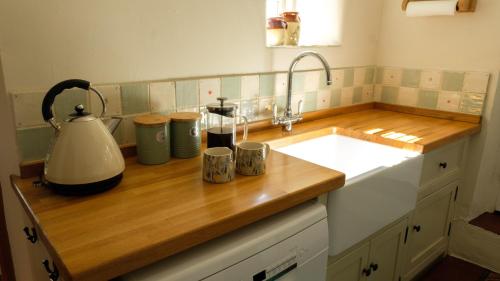 a kitchen counter with a sink and a mixer at Hope Cottage in Brassington