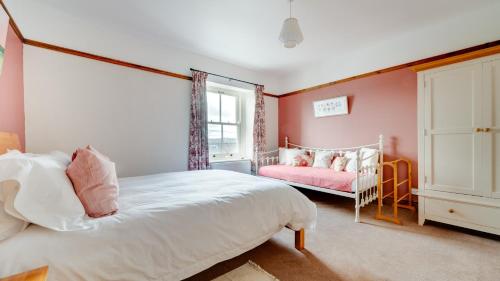 a bedroom with pink walls and a bed and a window at Springbank in Two Dales