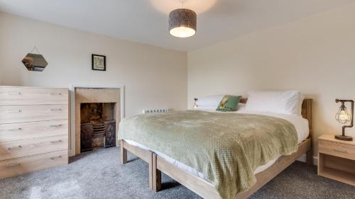 a bedroom with a bed and a dresser at Beau Cottage in Crich