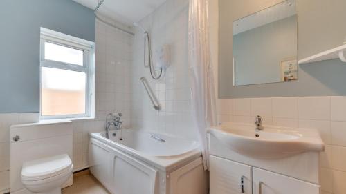 a white bathroom with a sink and a toilet at Stanton Lodge Cottage in Curbar