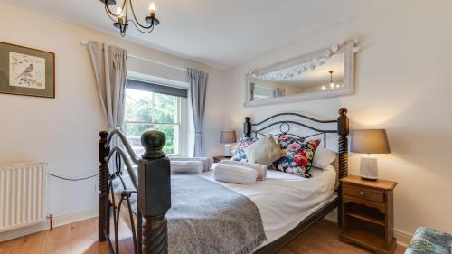 a bedroom with a bed and a window at Herbal Cottage in Eyam