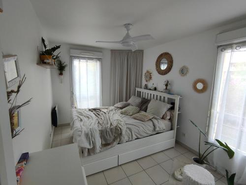 a white bedroom with a bed in a room at Au pied des calanques, nature, plages à 6min, parking, bus direct, idéal famille in Marseille