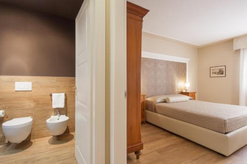a bedroom with a bed and a bathroom with a toilet at La Perla Apartment in Verona