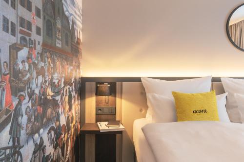 a hotel room with a bed and a wall with a painting at acora Augsburg Living the City - Apartments in Neusäß