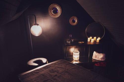 a dark room with a table and two mirrors at Le Carré Rose - Love Room proche de Rennes in Guichen