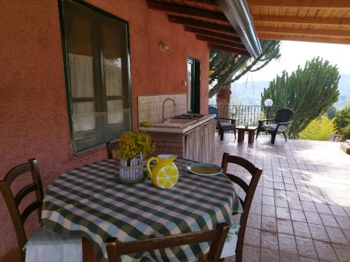 un tavolo con un vaso giallo su un patio di Villette Monte Alto a Patti