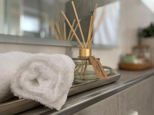 une serviette assise sur un comptoir de salle de bains avec une serviette dans l'établissement QT Apartments Detmold, à Detmold