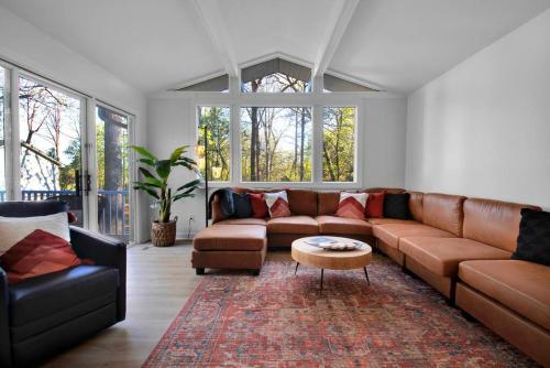 a living room with a brown couch and a table at Cozy Retreat near Paris Mtn State Park Sleeps 12 in Greenville