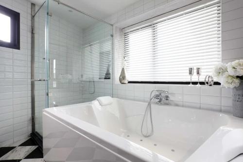 eine weiße Badewanne im Bad mit Fenster in der Unterkunft Hotel Dream - Luyen in Bangkok