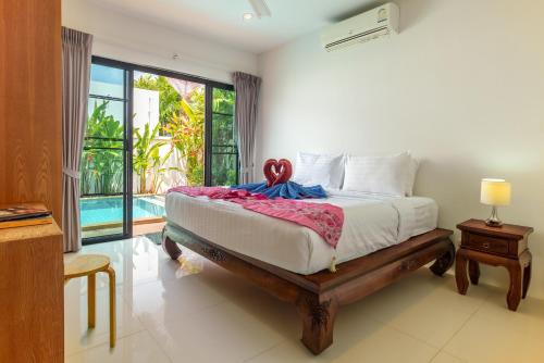 um quarto com uma cama e uma grande janela em Thai-Themed 3br Boutique Villa by Intira Villas em Praia de Rawai