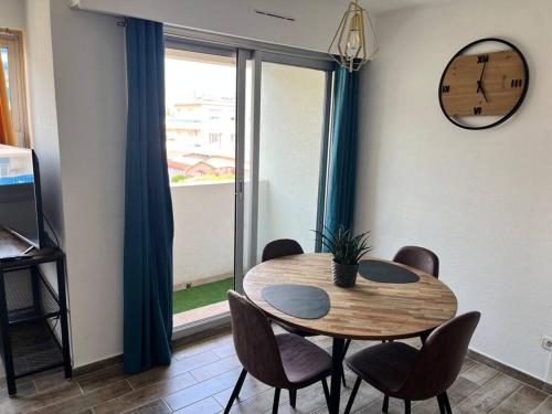 jadalnia ze stołem, krzesłami i zegarem w obiekcie grand studio proche plage w mieście Antibes