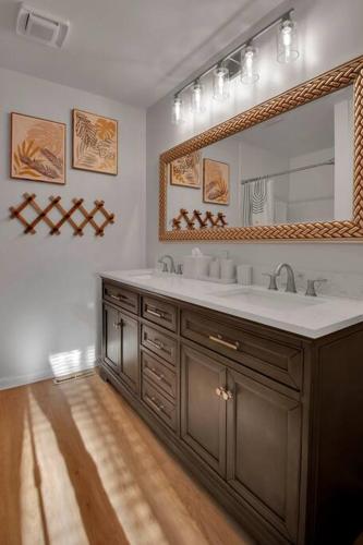 a bathroom with a sink and a large mirror at Cozy Retreat near Paris Mtn State Park Sleeps 12 in Greenville