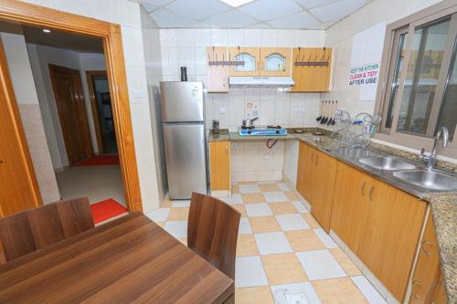 a kitchen with a sink and a refrigerator at SARJAK'S HOSTEL MANKHOOL in Dubai