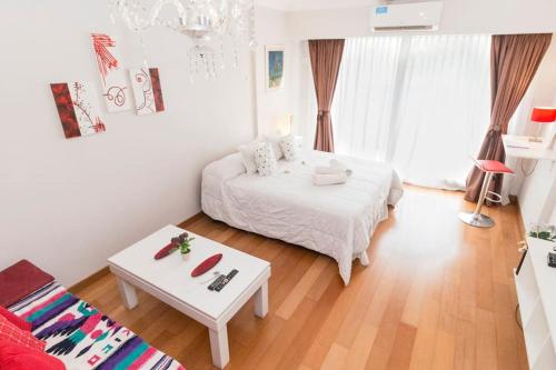 Departamento en Peña Recoleta MODERNO Y LUMINOSO في بوينس آيرس: غرفة نوم بيضاء مع سرير أبيض وطاولة