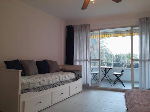 a bedroom with a bed and a view of a balcony at Apartment with pool near the beach in Marbella