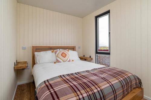 1 dormitorio con cama y ventana en Amazing Views Off Grid Cabin en Duncanston
