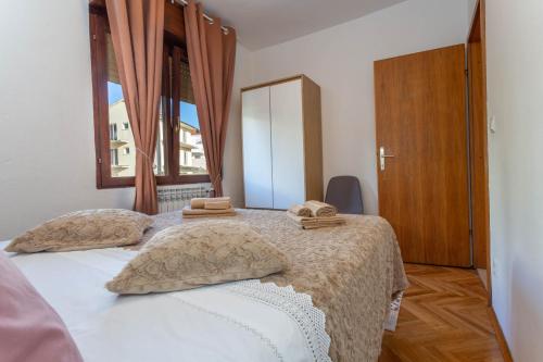 a bedroom with a bed with two towels on it at Apartment Hedonist in Hvar