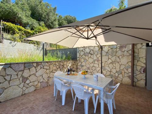 a table and chairs with an umbrella on a patio at Sweet home in Mandra Capreria