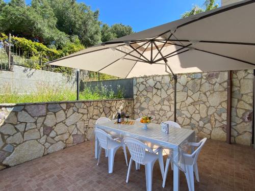 a white table and chairs under an umbrella at Sweet home in Mandra Capreria