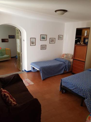 ラヴェーノ・モンベッロにあるAppartamento Piccolo Porto di Cerroのリビングルーム(ベッド2台、ソファ付)