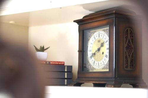 un reloj de madera sobre un estante en Residenza del Corso, en Trani