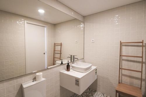 Baño blanco con lavabo y espejo en Douro Dreams, en Oporto