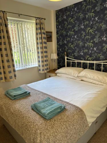 a bedroom with a bed with two towels on it at Fernhill Retreat in Charmouth