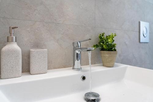 a white sink with a soap dispenser and a bottle on it at Villa Kalligoni in Kalligónion