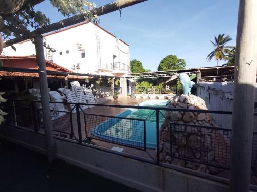 a bird sitting on a fence next to a pool at Pousada Miosotis in Nova Viçosa