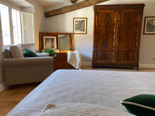 a bedroom with a large wooden cabinet and a couch at Burlamacchi Villas in Bagni di Lucca