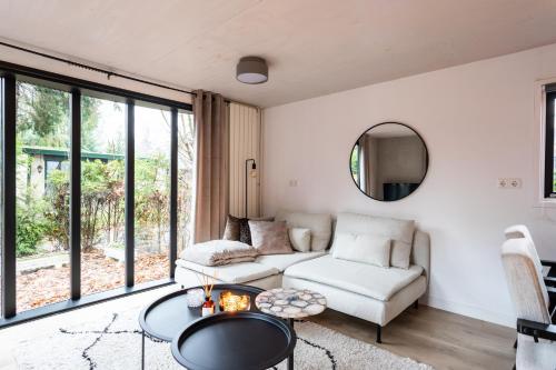 a living room with a couch and a table at Boutique Chalet Veluwe in Putten