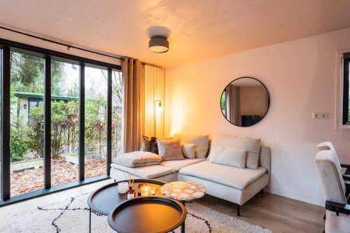 een woonkamer met een bank en een tafel bij Boutique Chalet Veluwe in Putten