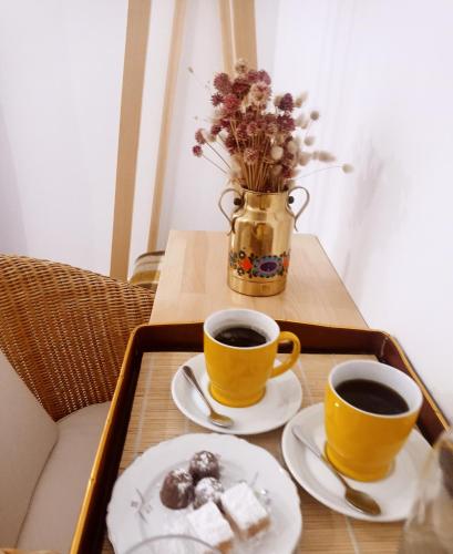two cups of coffee and cookies on a table at ELÉA Guesthouse himare in Himare
