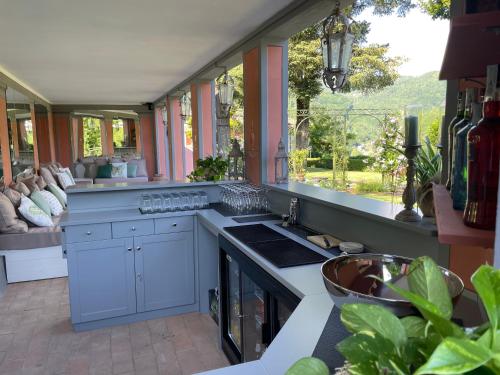 a kitchen with blue cabinets and a large window at Burlamacchi Villas in Bagni di Lucca