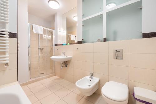 a bathroom with a toilet and a sink and a shower at Mokotów Open Business Apartment in Warsaw