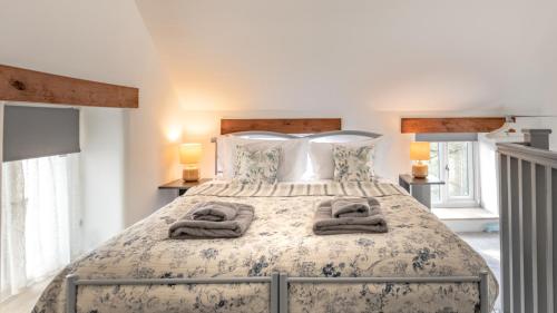 a bedroom with a large bed with towels on it at Little Hillside in Ashover