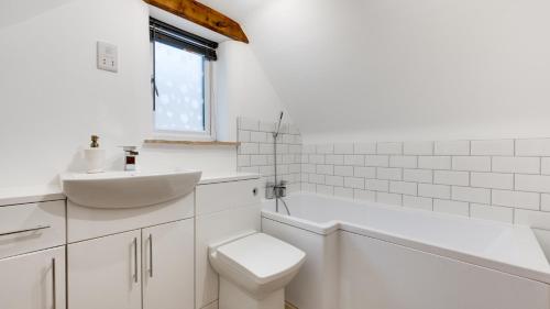 a white bathroom with a sink and a toilet at Little Hillside in Ashover