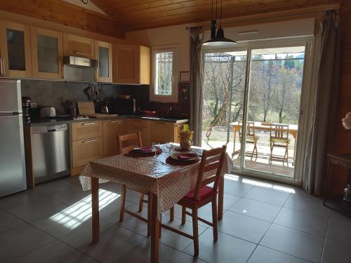 La Prairie في Noyers-sur-Jabron: مطبخ مع طاولة وكراسي مع طاولة وطاولة ومطبخ