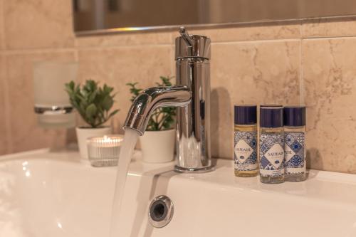 a sink with a faucet and two candles on it at Vittoria Garden Suites in Rome